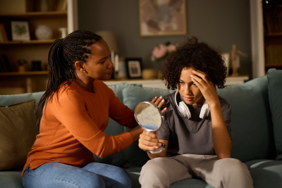 mom and teenage son looking in mirror discussing body changes puberty